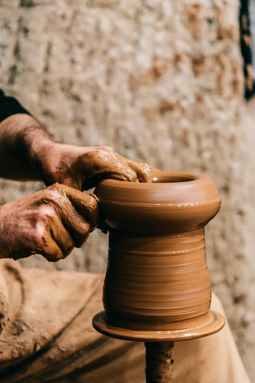 man shaping vase on pottery wheel
